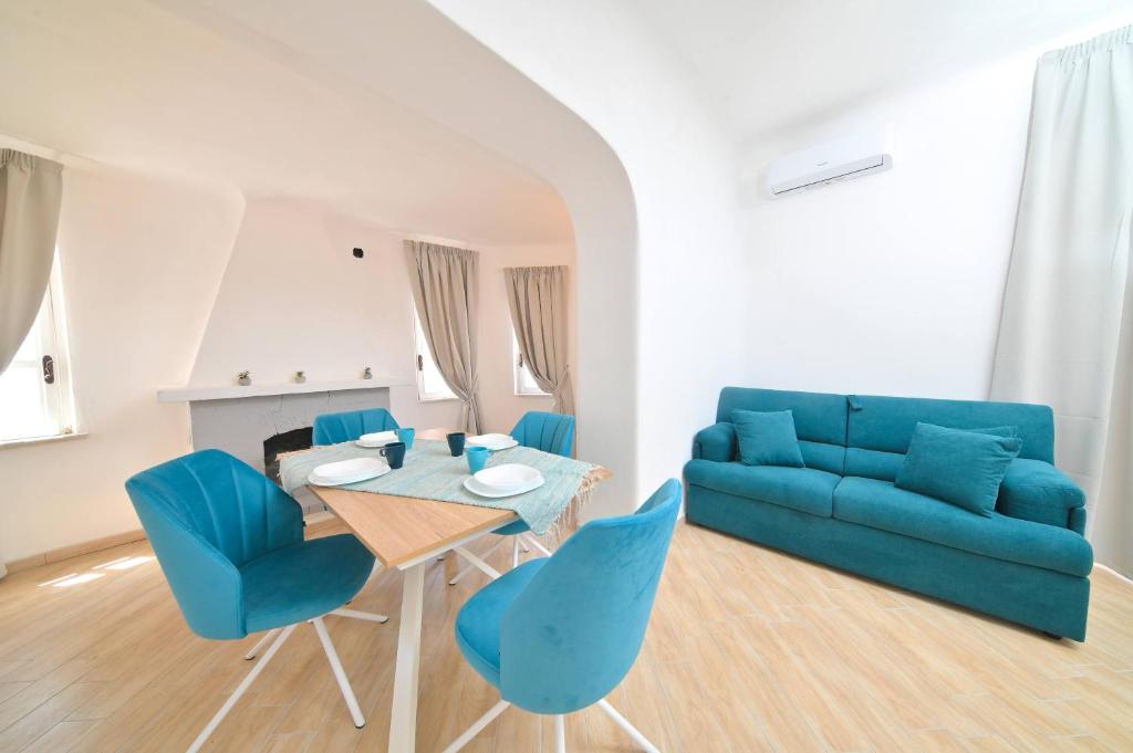 伊斯基亚Villa Aida的客厅配有蓝色的沙发、桌子和椅子