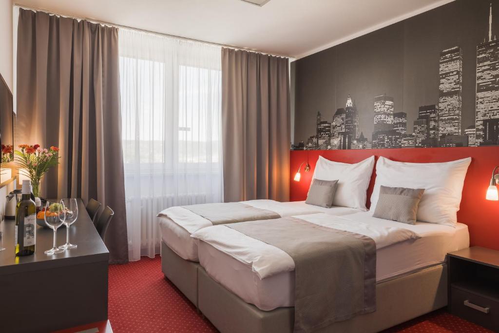 布尔诺维史塔酒店的一间卧室配有一张大床和红色床头板