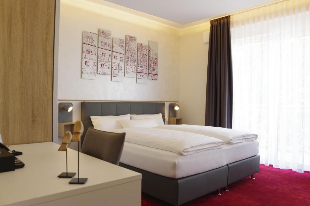爱尔福特Hotel am Waldkasino的配有一张床和一张书桌的酒店客房