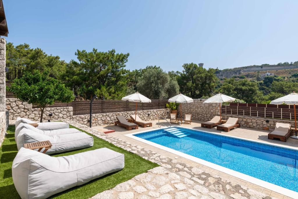 依克希亚Adonis Villa in nature的一个带躺椅的游泳池和一个游泳池