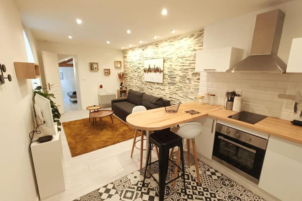 昂热Douceurs Angevine的一间厨房和客厅,客厅内配有木桌。