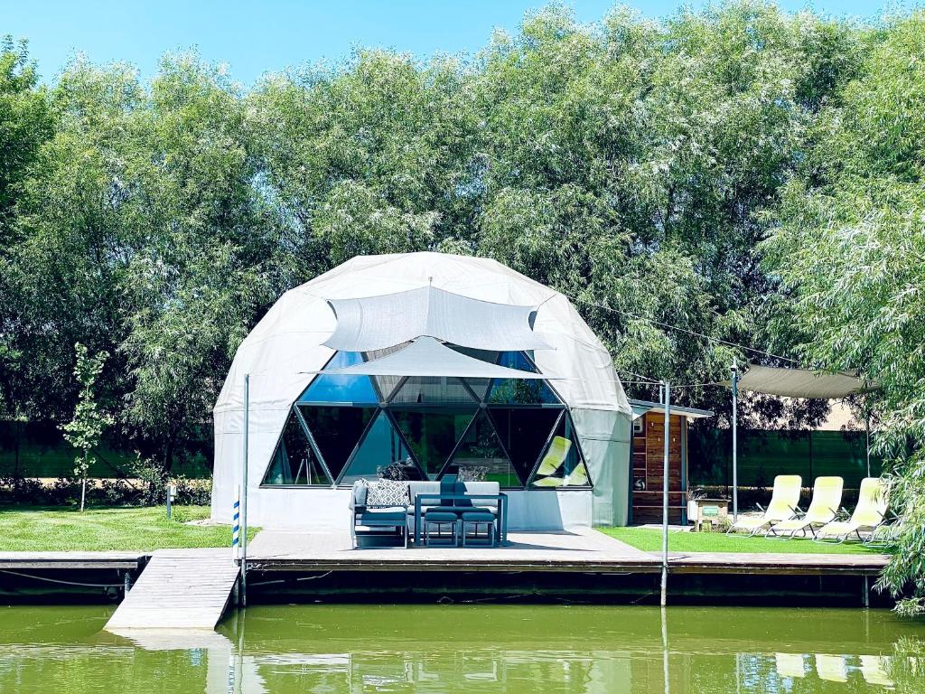 SágvárDOMEGLAMPING at FISHINGLAKE的一个带桌子和椅子的凉亭