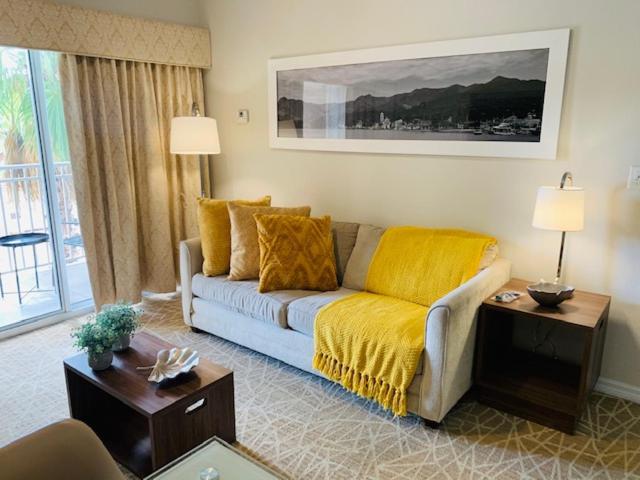 奥兰多Amazing 1 Bedroom Resort 2 miles from Universal的客厅配有一张带黄色毯子的沙发