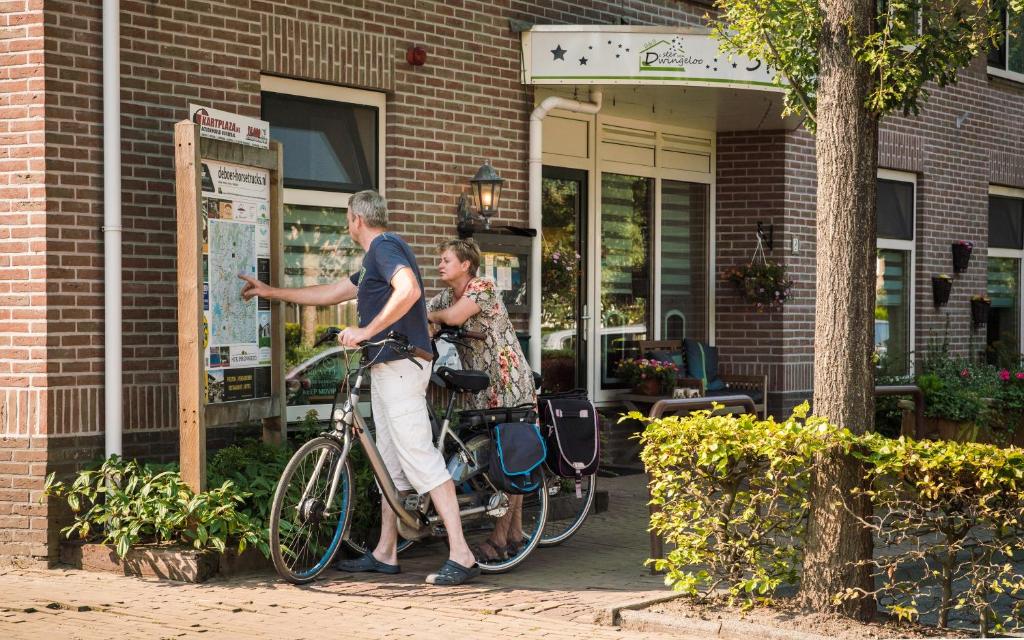 德文格洛B&B de Ster van Dwingeloo的站在自行车旁的男人和女人