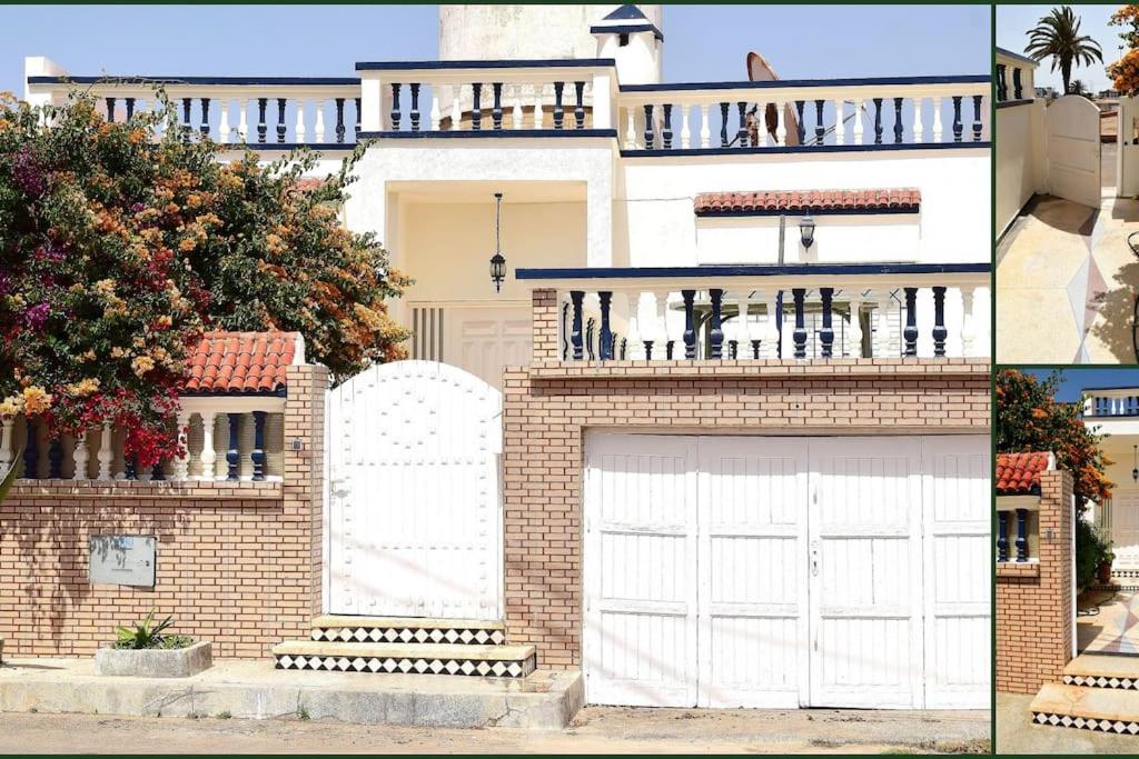 Souira GuedimaLot 46的一座带白色车库门和一座建筑的房子