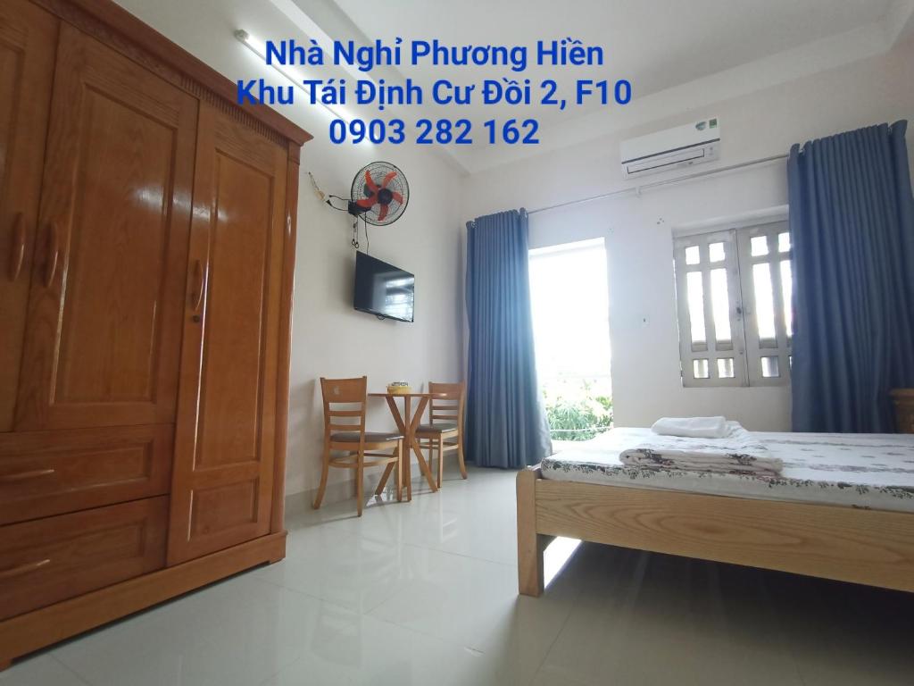 头顿Nhà nghỉ PHƯƠNG HIỀN的卧室配有一张床和一张桌子及椅子