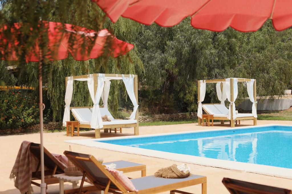 桑帕克Llucatx Menorca的两把躺椅和一个带遮阳伞的游泳池