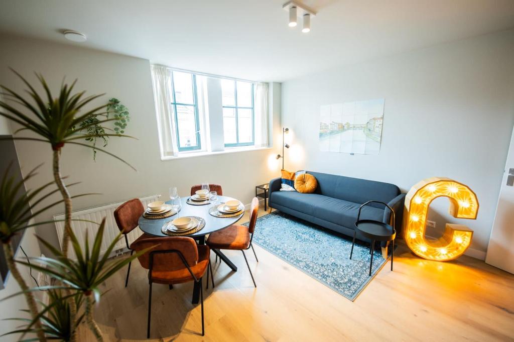 鹿特丹Cool 3 Bedroom Serviced Apartment 68m2的客厅配有蓝色的沙发和桌子