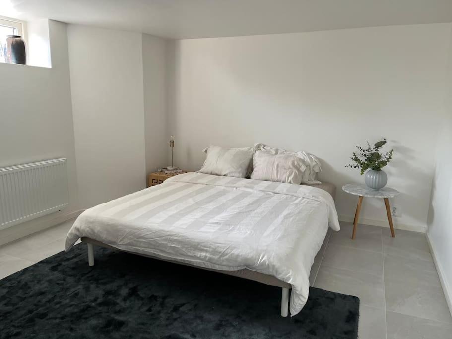 哥德堡Boende nära centrum och natur的白色卧室配有一张大床和一张桌子