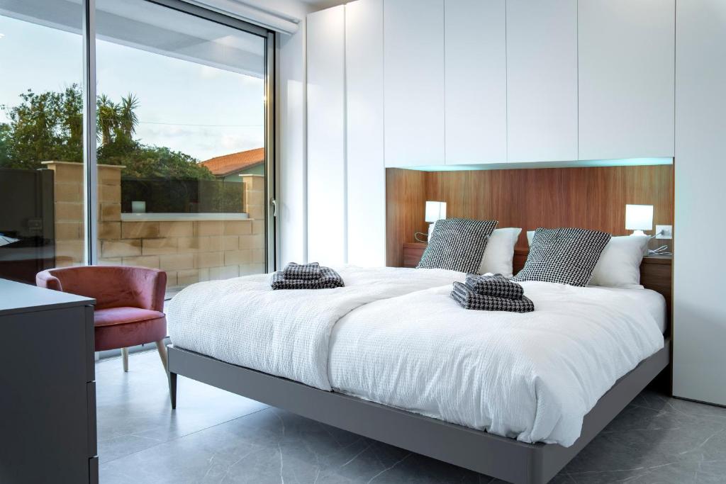 奥里斯塔诺Appartamento Guglielmo的卧室配有一张白色大床和一把椅子