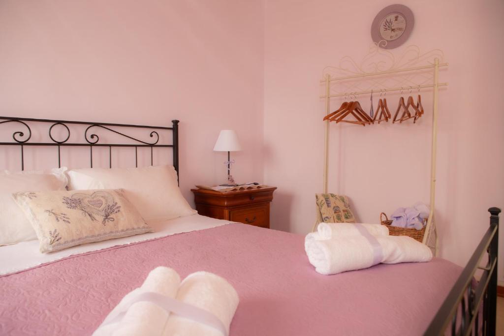 阿夸维瓦皮切纳La Casa del Gelsomino的卧室配有一张床,墙上挂着一个钟