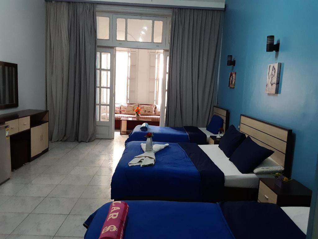 开罗Hostgram Hotel的卧室设有两张床铺和蓝色的墙壁