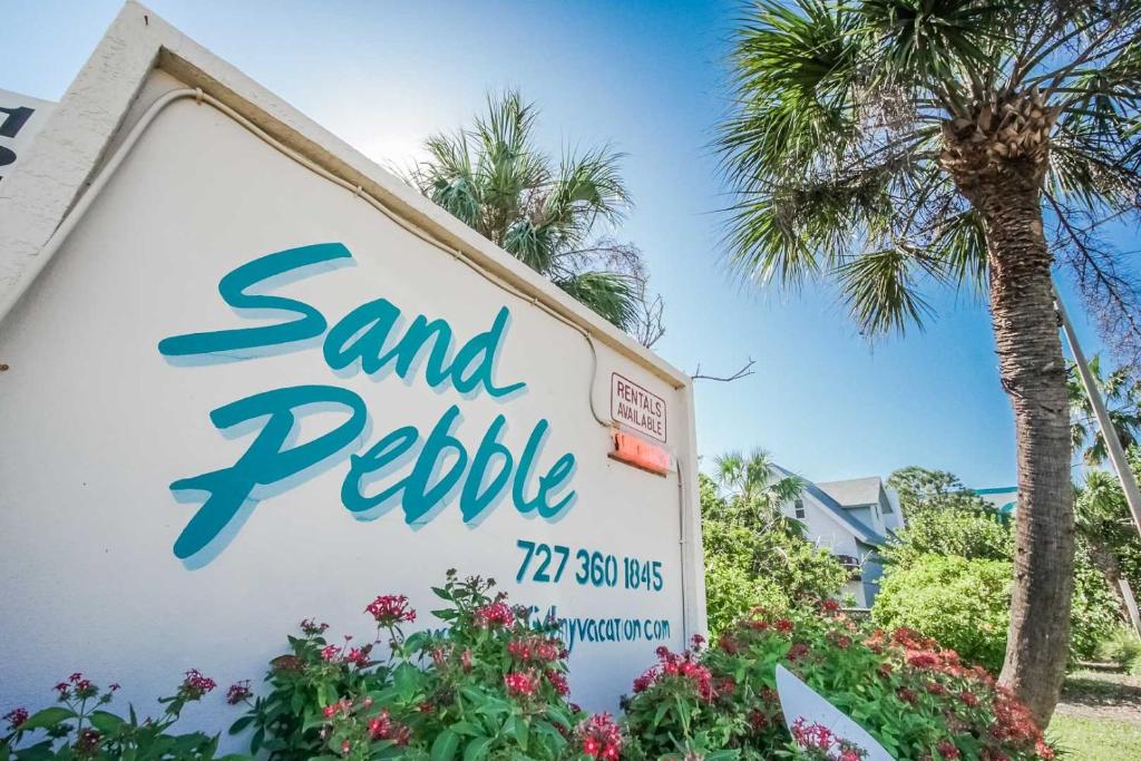 圣徒皮特海滩Sand Pebble Resort的棕榈树沙石酒店标志