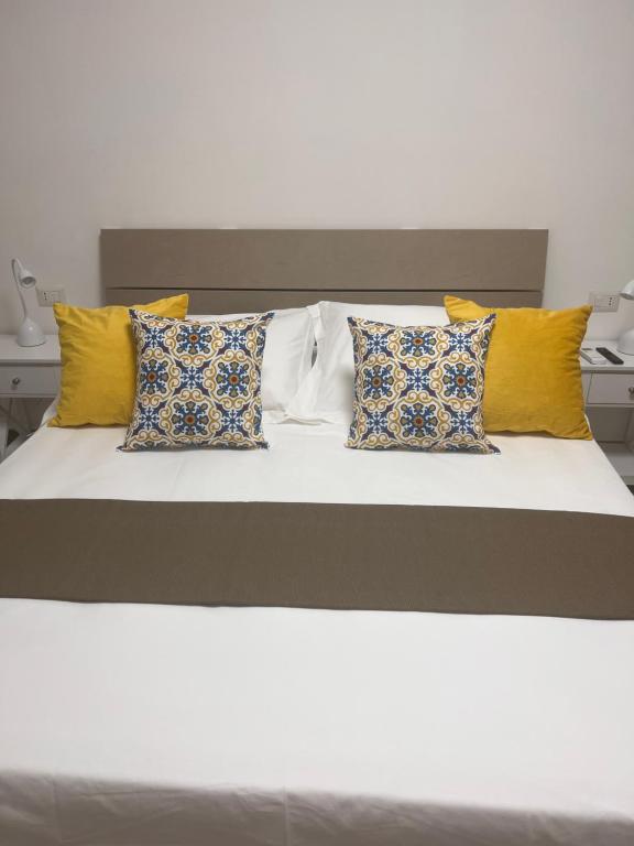 那不勒斯City Home 77的一张黄色和蓝色枕头的床