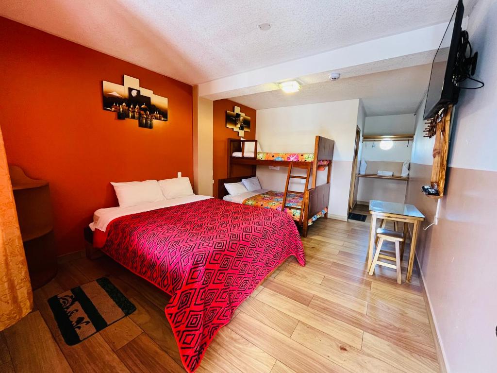 塔巴贝拉Hostal Alpachaca - New Quito Airport的一间卧室配有红色的床和一张小桌子
