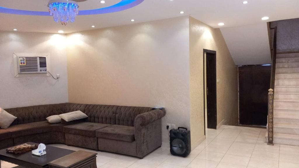 延布شاليه سحاب的客厅配有棕色沙发和吊灯。