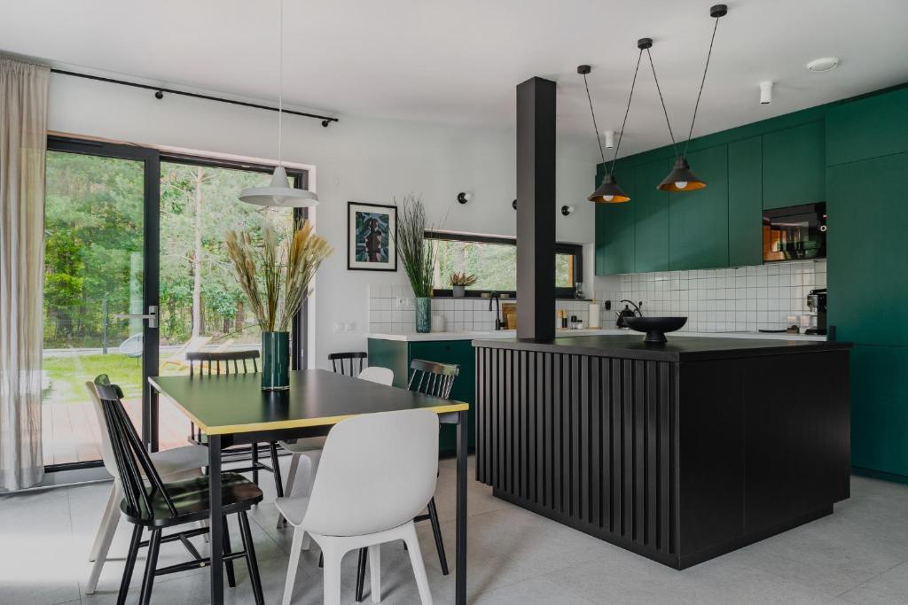 Domek z basenem nad Bugiem的厨房配有绿色橱柜和桌椅
