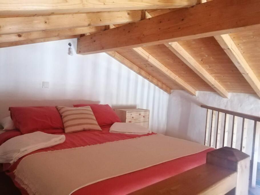 圣特奥托纽Monte Alentejano ideal para relaxar na natureza的阁楼上一张铺有红白床单的床