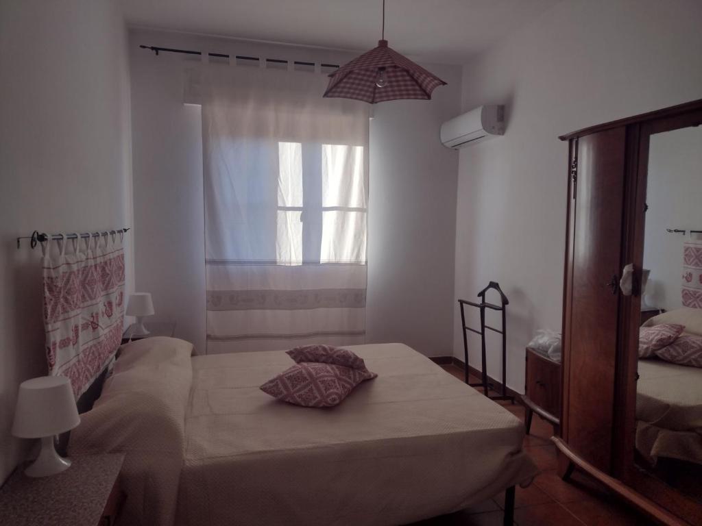 卡尔博尼亚Sa domu de Peppinu的一间卧室设有一张床和一个窗口