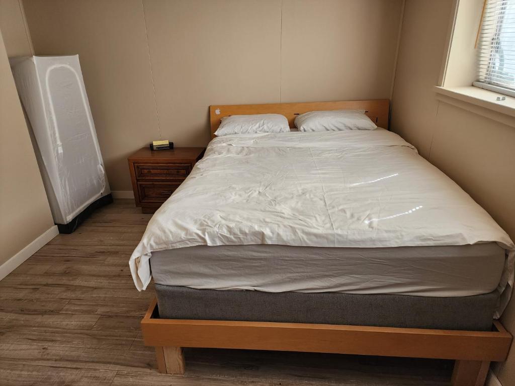 伯纳比Economical Homestay的一间卧室配有一张大床和木制床头板