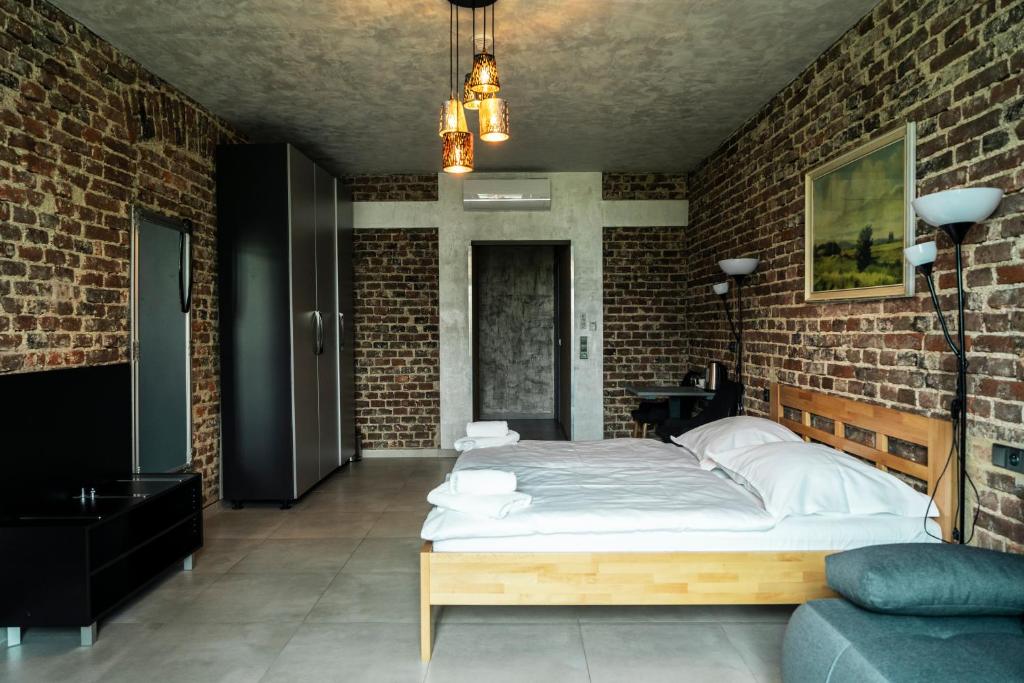 普日布拉姆Hotel JURKOS的卧室设有一张砖墙内的大床