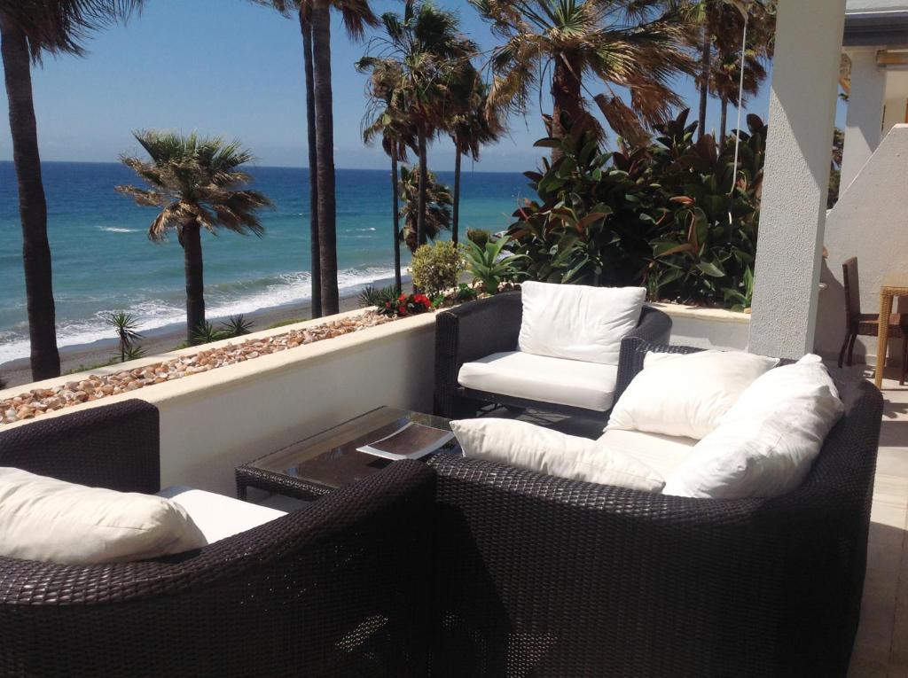 EsteponaDominion Beach Apartment的阳台配有两把椅子,享有海滩美景