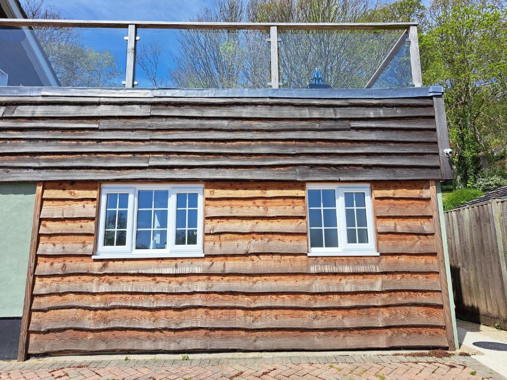 WhitwellSylvan Seas的小木屋设有2扇窗户和围栏