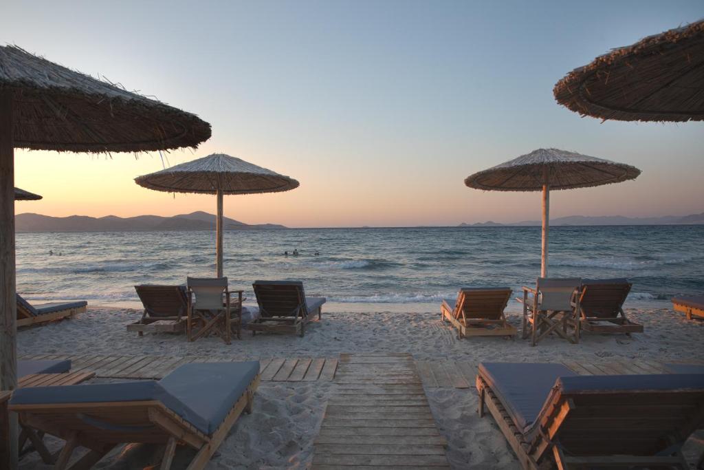 蒂加基Philippos & Alexandros Apartments的海滩上设有椅子和遮阳伞,还有大海