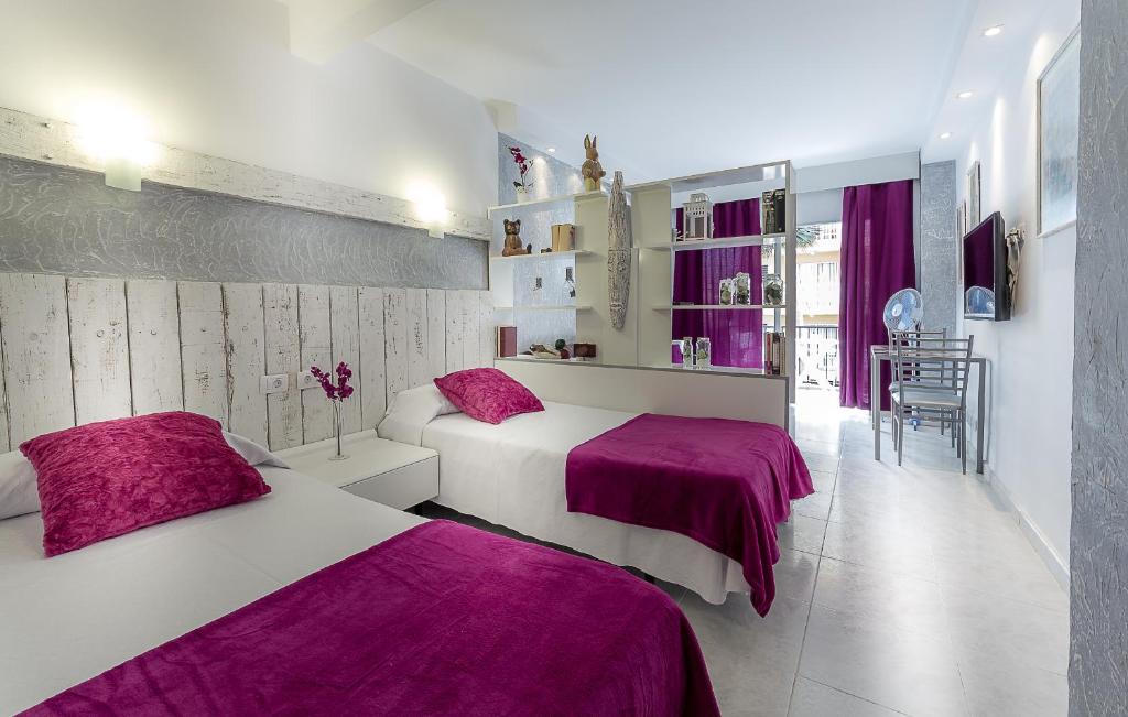 拉克鲁斯Seguro de Sol Studios的一间卧室配有两张紫色床单