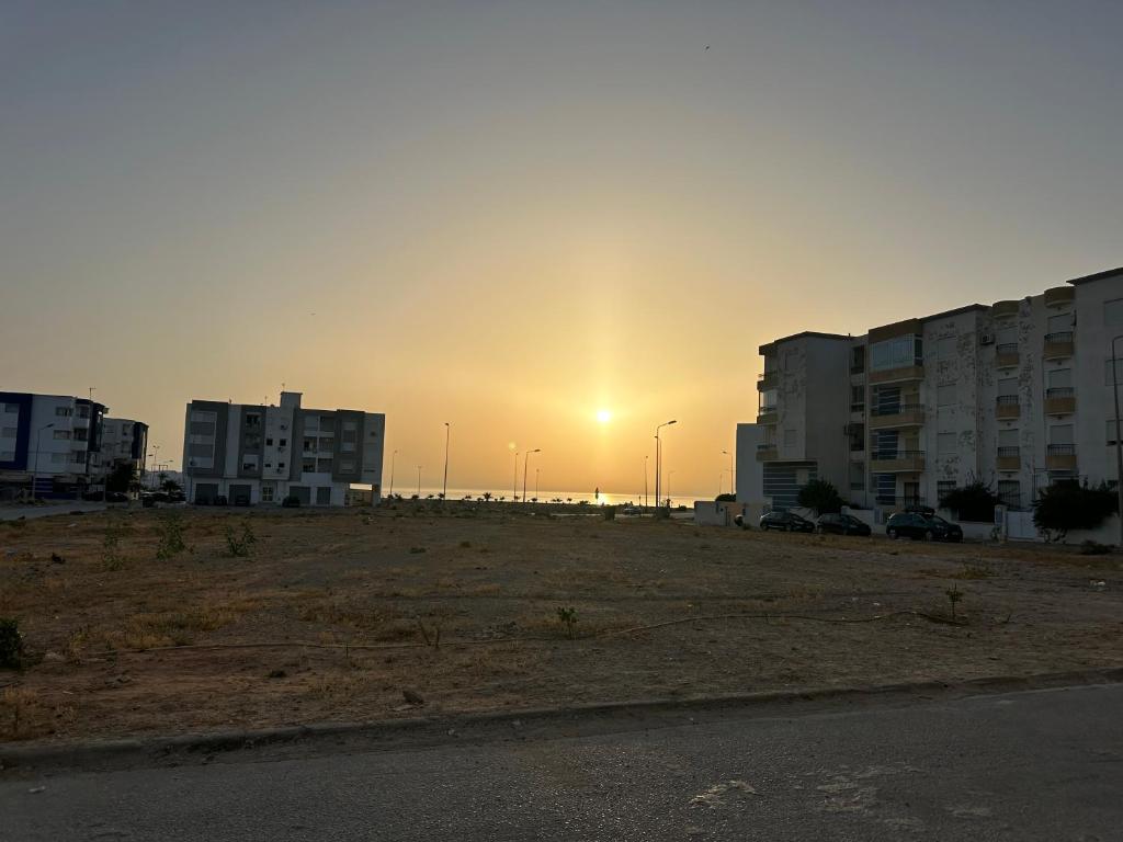 海尔盖莱Sousse Beach luxe的空的停车场,阳光在建筑后面