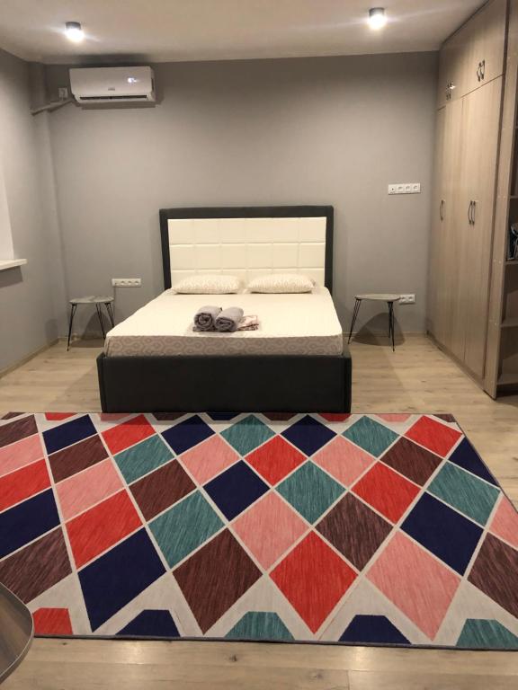 阿拉木图Уютная квартира в центре города的一间卧室配有床和色彩缤纷的地毯。