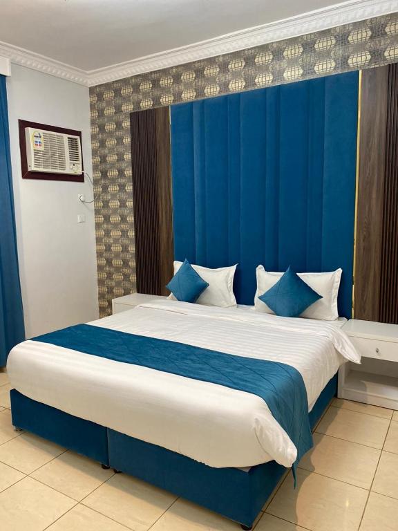 阿哈达منتجع أرين للوحدات السكنية的一间卧室配有一张带蓝色窗帘的大床