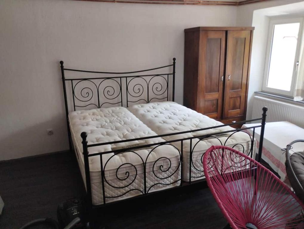 伊德里亚Lux apartments and rooms Dogs baronesse Idrija的一间卧室配有一张带木制橱柜的床和红色风扇。