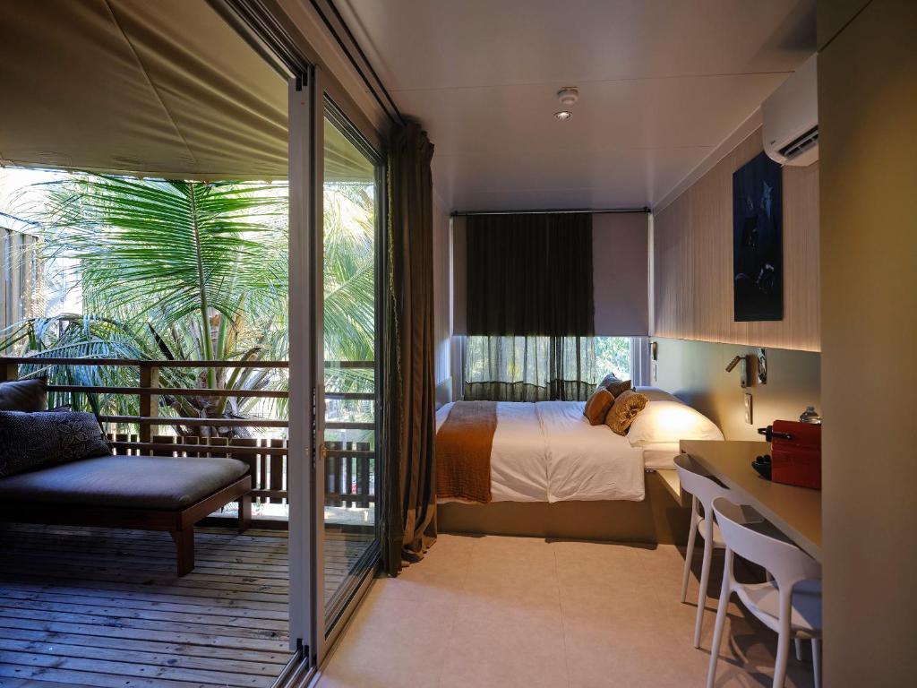 Kani Keli茂瑞花园酒店的酒店客房设有一张床和一个阳台。