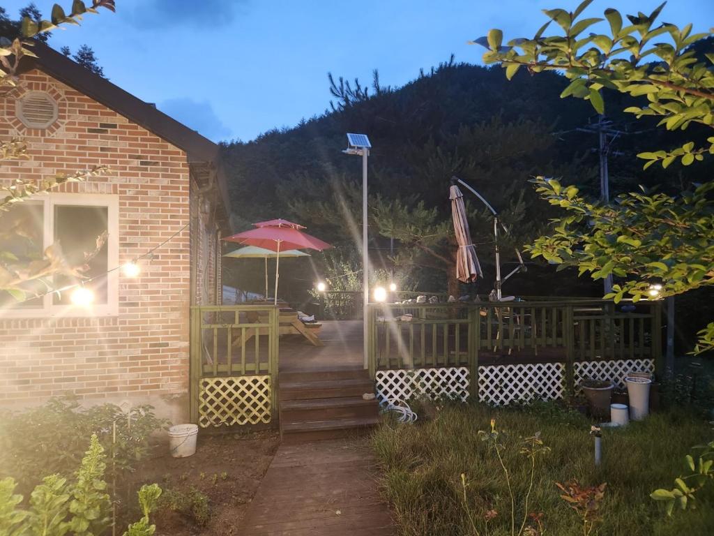 江陵市Samhyeongjebonggil Pension的一座带庭院和遮阳伞的房子