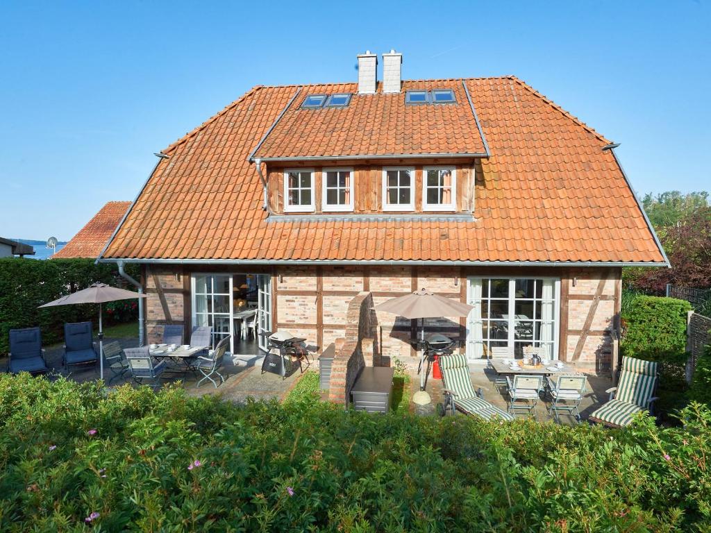 塞多夫Fachwerkhäuser Seedorf - Haushälfte "Sophie Charlott" mit Kamin und Terrasse的一座带桌椅的橙色屋顶房子