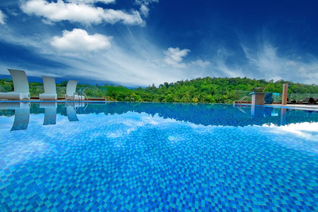 康提金皇冠酒店的一座带蓝色水和白色椅子的大型游泳池