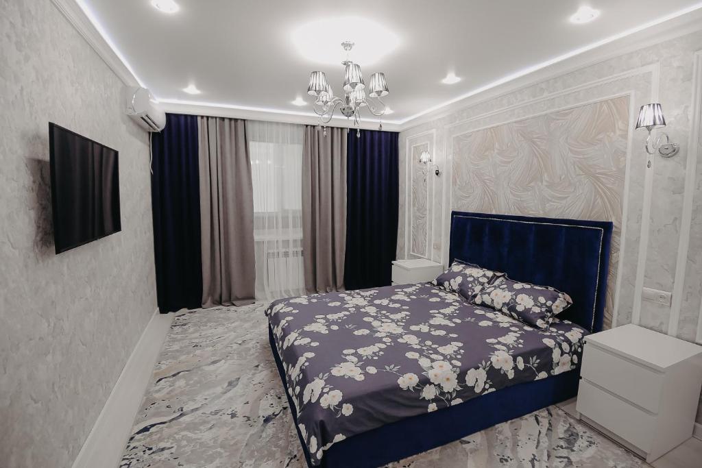 乌拉尔斯克VIP апартаменты однокомнатная квартира的一间卧室配有蓝色的床和吊灯。