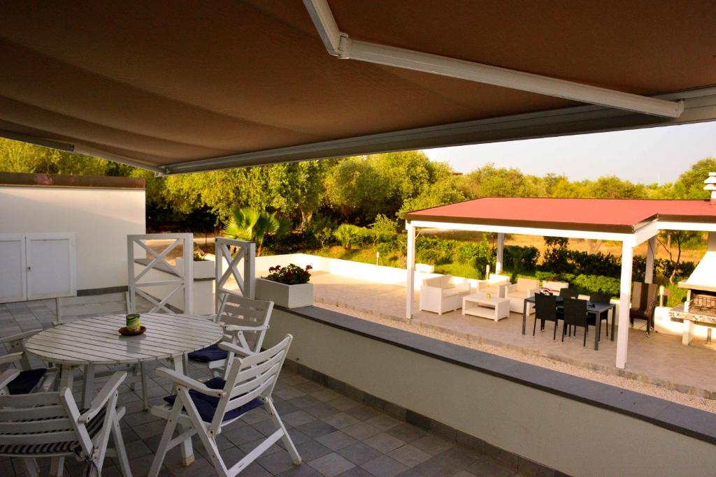 阿尔盖罗PM Villa Tania Guest House的一个带桌椅的庭院和一个凉亭