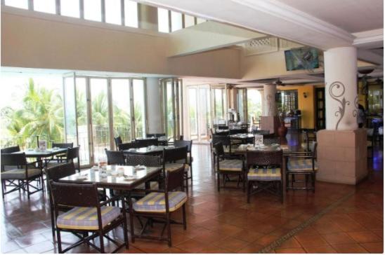 波德申Seafront Corus Resort Port Dickson的用餐室设有桌椅和窗户。