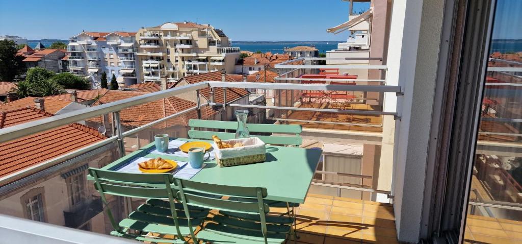 阿卡雄Superbe appartement centre-ville 5 min de la plage的设有一个配有桌椅并享有美景的阳台。