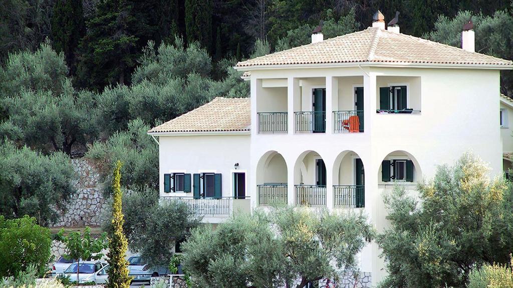 耶尼翁Villa Evgenia的带阳台和树木的大型白色房屋