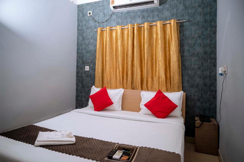 古瓦哈提Hotel Town and country inn ( a unit of GS RESIDENCY)的一张带红色和白色枕头的床