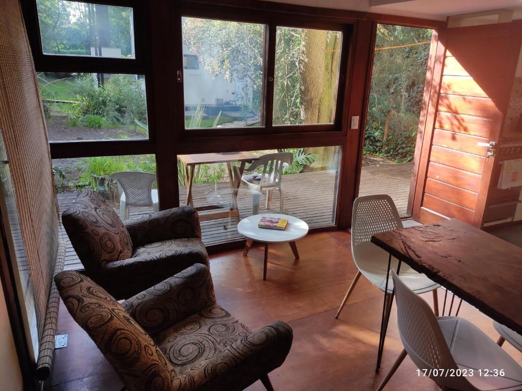 马德普拉塔Cabaña UMA - Rumi Huasi的客厅配有沙发、椅子和桌子
