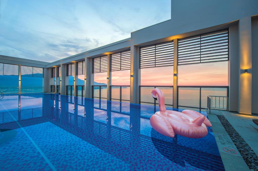 岘港岘港福朋喜来登酒店的游泳池内有2个粉红色的火烈鸟