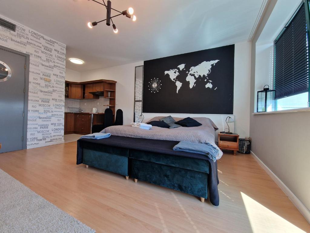 科沃布热格Apartament Słoneczny的卧室配有一张大床,墙上挂有地图