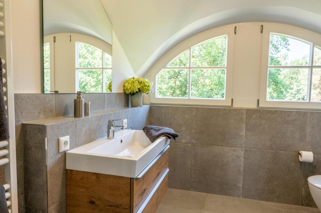 博恩Lieblingshof的一间带水槽的浴室和两个窗户