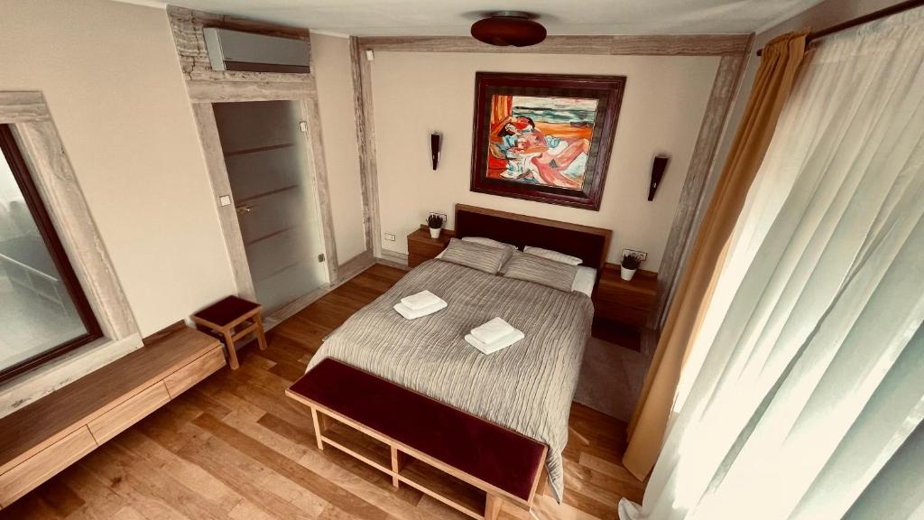 哈日科维贝尔维尤酒店的卧室配有一张床,墙上挂有绘画作品