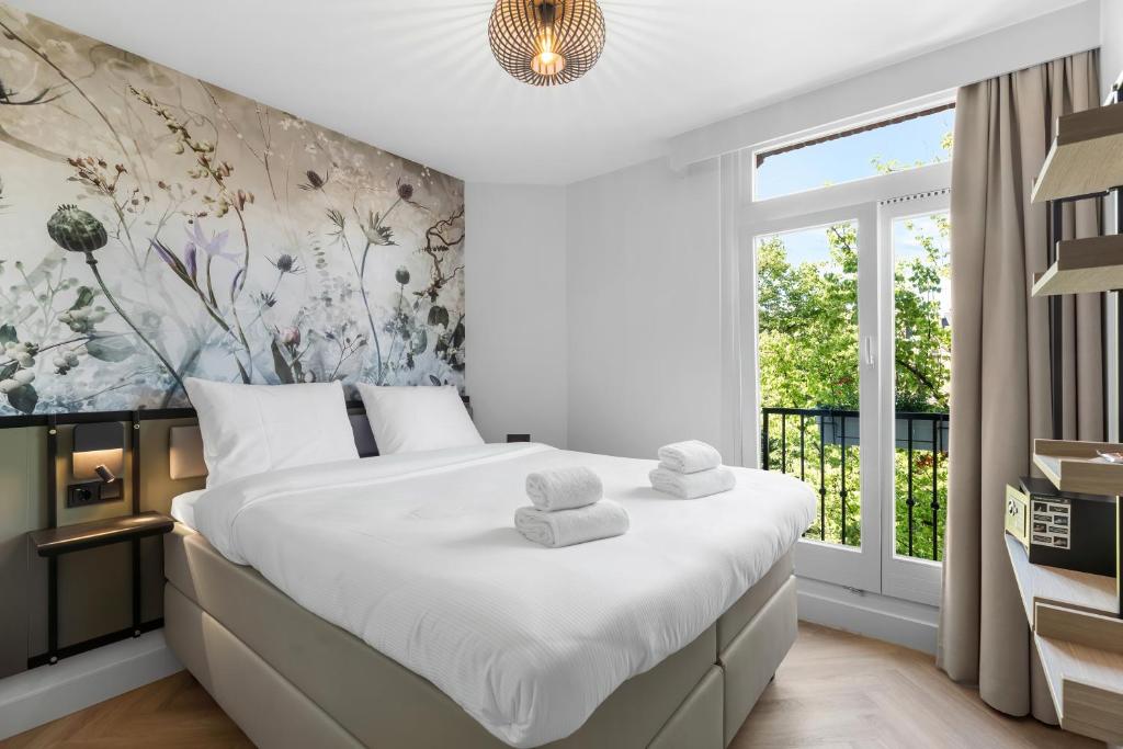 阿姆斯特丹Dutch Design Hotel Vondelpark的一间卧室配有一张大床和毛巾