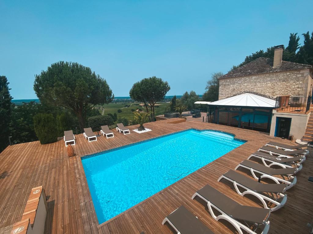 蒙巴兹雅克Villa Monbazillac, vue exceptionnelle, piscine, jacuzzi 10-16 pax的一座带椅子的游泳池以及一座建筑